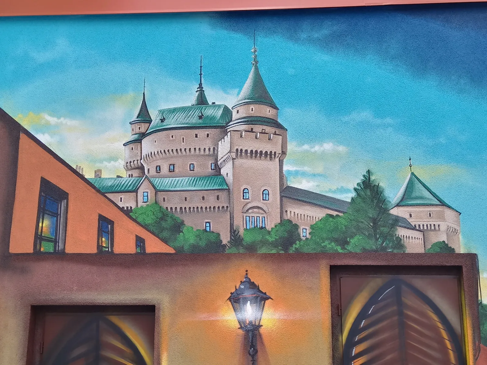 Iluzivní fasádní malba zámku s oblohou a lucernou